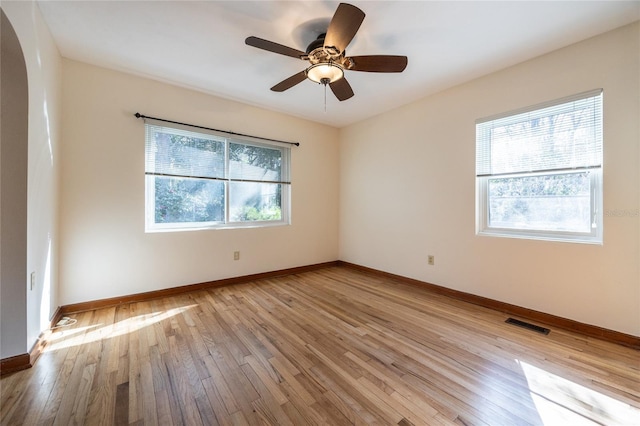 empty room with ceiling fan and light hardwood / wood-style flooring