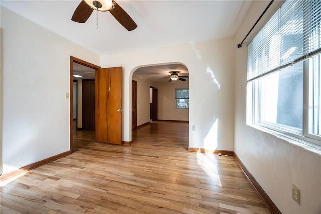 empty room with ceiling fan and light hardwood / wood-style flooring