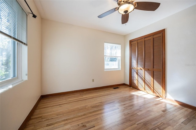 unfurnished bedroom with a closet, ceiling fan, and light wood-type flooring