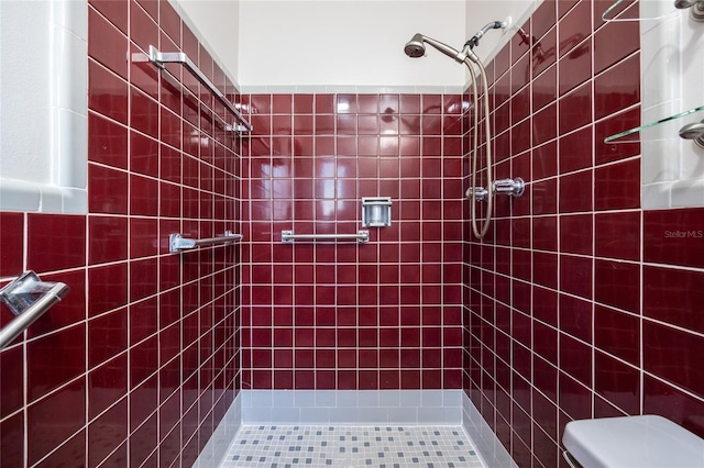 bathroom with tiled shower and toilet