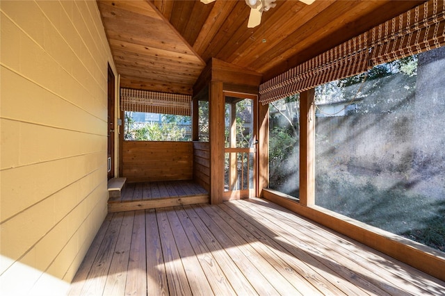 unfurnished sunroom featuring lofted ceiling, plenty of natural light, wooden ceiling, and ceiling fan