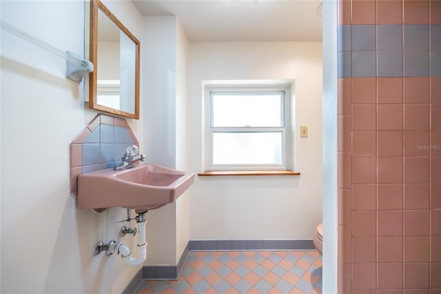 bathroom with sink, backsplash, and toilet