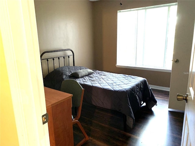 bedroom with dark wood-type flooring