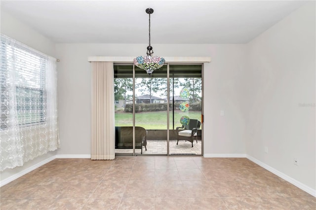 empty room featuring a healthy amount of sunlight and light tile patterned floors