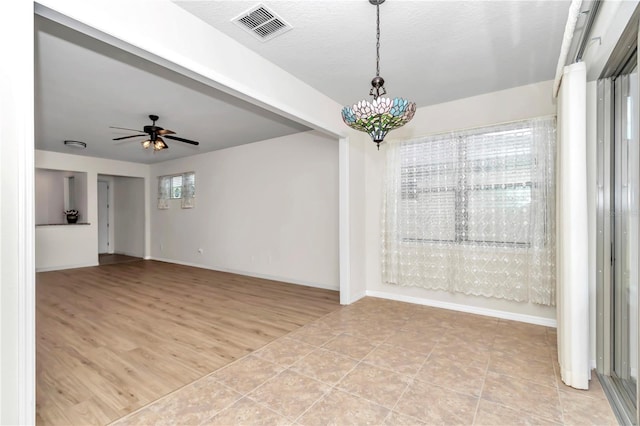 empty room with ceiling fan and light hardwood / wood-style flooring