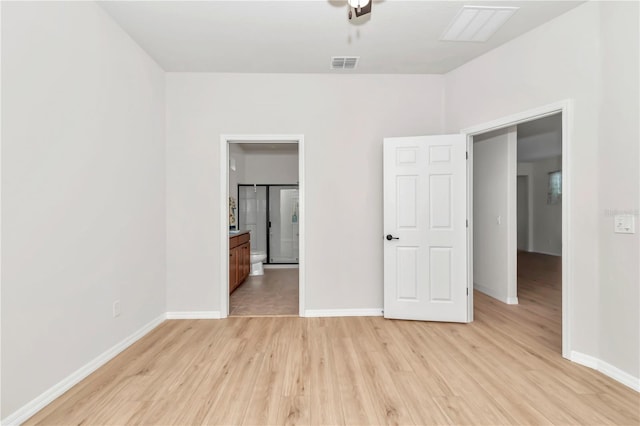 unfurnished bedroom with ensuite bath and light hardwood / wood-style flooring