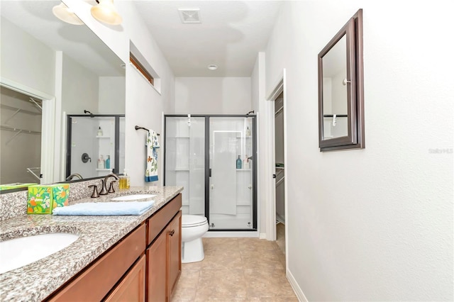 bathroom featuring vanity, toilet, and walk in shower