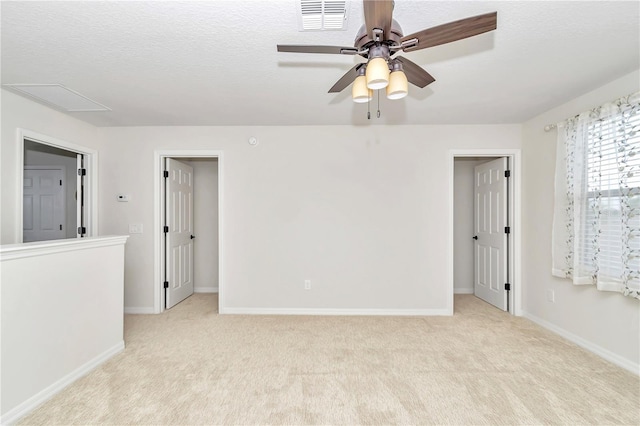 carpeted spare room featuring ceiling fan and a textured ceiling