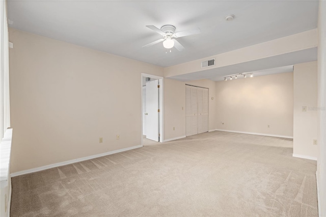 unfurnished room featuring light colored carpet, rail lighting, and ceiling fan