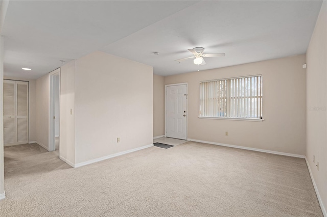 empty room featuring light colored carpet and ceiling fan