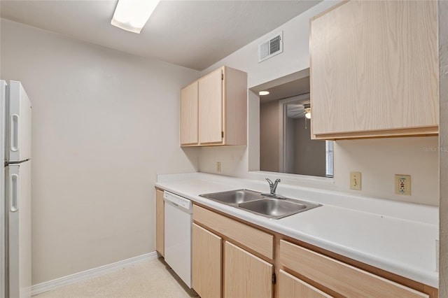 kitchen featuring light brown cabinetry, sink, and white appliances