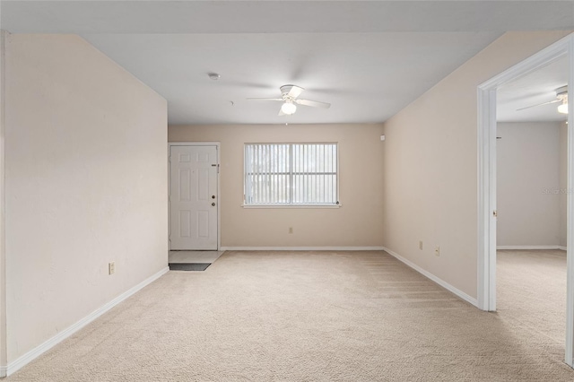 carpeted spare room featuring ceiling fan