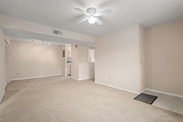 spare room with ceiling fan, rail lighting, and light carpet