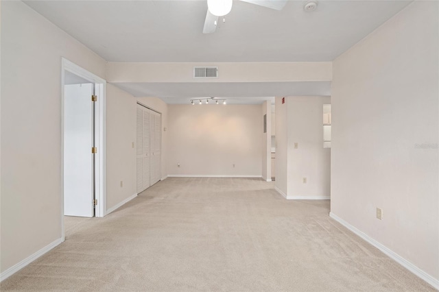 carpeted empty room featuring ceiling fan and rail lighting