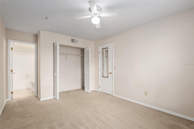 unfurnished bedroom with ceiling fan, light colored carpet, and a closet