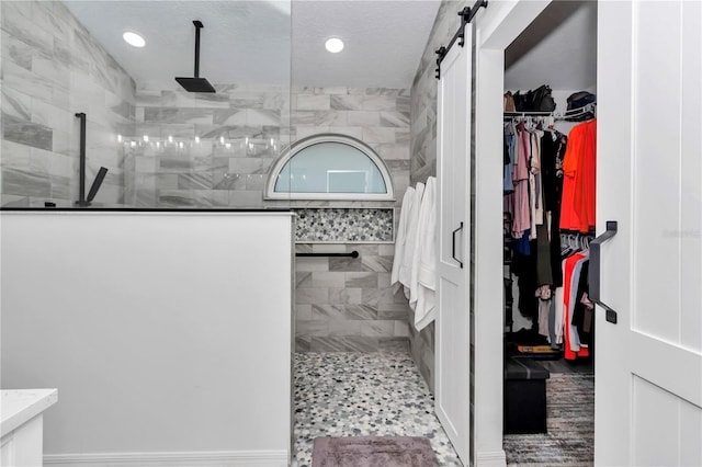 full bath featuring recessed lighting, a spacious closet, and walk in shower