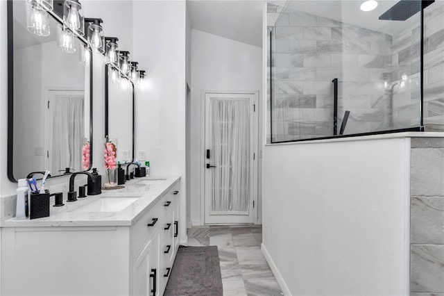 bathroom featuring marble finish floor, double vanity, a sink, and a walk in shower