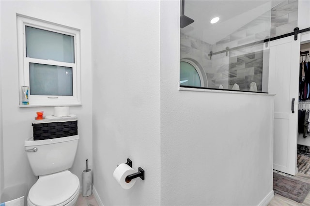 bathroom with toilet, baseboards, vaulted ceiling, and tiled shower