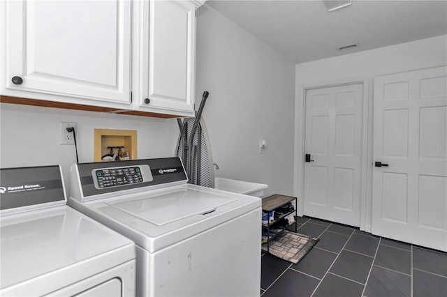 washroom featuring cabinet space, visible vents, separate washer and dryer, and dark tile patterned flooring