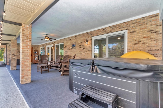 view of patio / terrace featuring ceiling fan and a hot tub