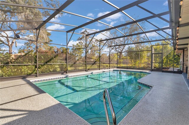 outdoor pool featuring glass enclosure and a patio