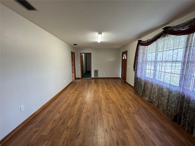 spare room with wood-type flooring and a textured ceiling