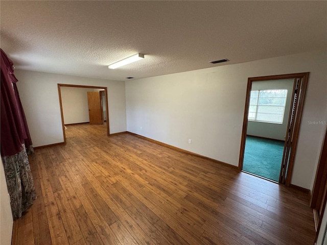 empty room featuring hardwood / wood-style floors and a textured ceiling