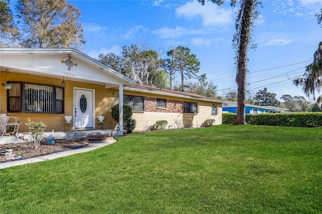 single story home featuring brick siding and a front yard