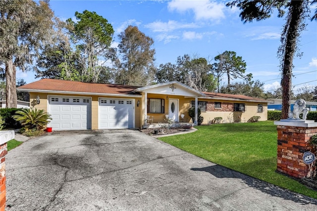 ranch-style home featuring driveway, an attached garage, and a front yard