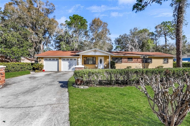 ranch-style house featuring a garage, stucco siding, aphalt driveway, and a front yard