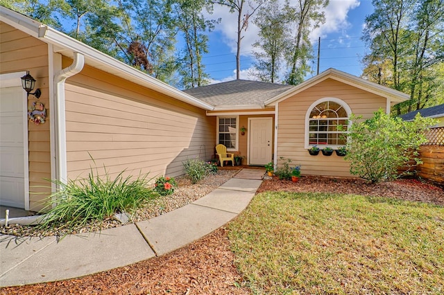 entrance to property with a yard and a garage