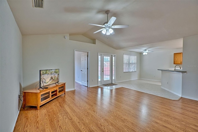 living room with lofted ceiling, light hardwood / wood-style floors, and ceiling fan