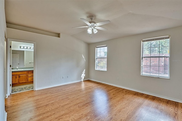 spare room featuring ceiling fan, lofted ceiling, sink, and light hardwood / wood-style floors