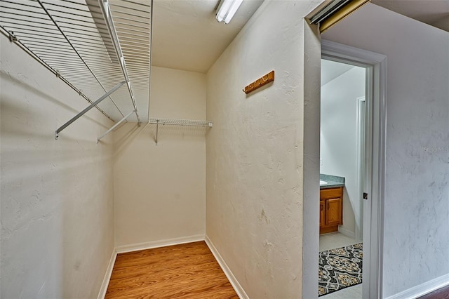 spacious closet with light hardwood / wood-style floors