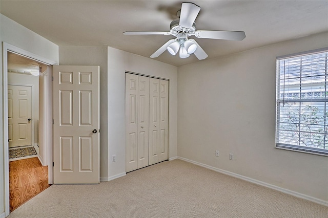 unfurnished bedroom with light carpet, ceiling fan, and a closet