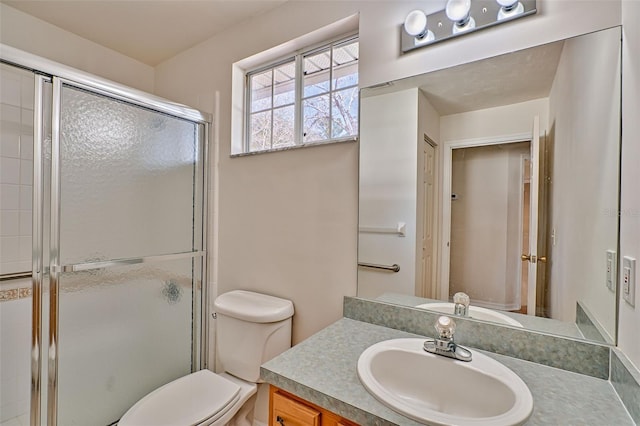 bathroom with vanity, a shower with shower door, and toilet