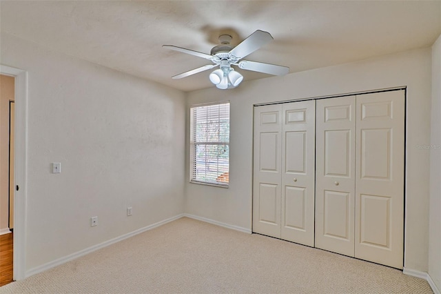 unfurnished bedroom with light carpet, a closet, and ceiling fan