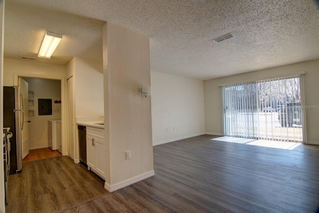 interior space with dark hardwood / wood-style flooring, a textured ceiling, and washing machine and clothes dryer