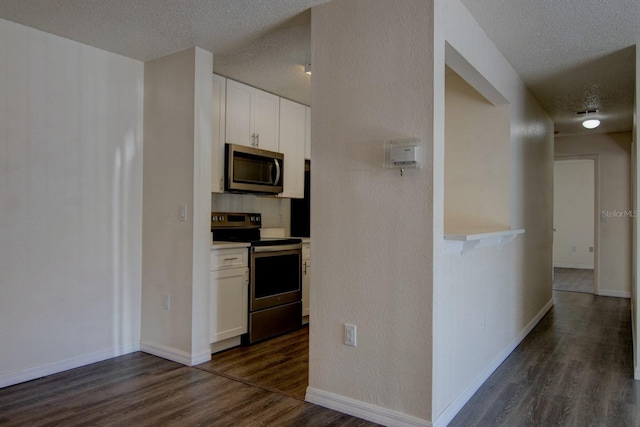 kitchen with white cabinetry, dark hardwood / wood-style floors, a textured ceiling, and appliances with stainless steel finishes