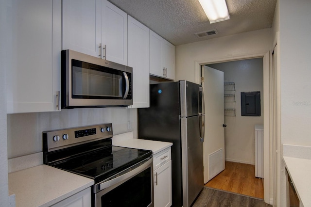 kitchen featuring appliances with stainless steel finishes, white cabinetry, electric panel, a textured ceiling, and dark hardwood / wood-style flooring