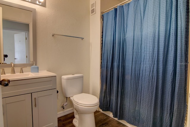 bathroom with walk in shower, wood-type flooring, toilet, and vanity