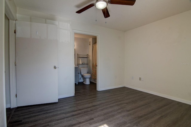 unfurnished bedroom with ensuite bathroom, dark hardwood / wood-style floors, and ceiling fan