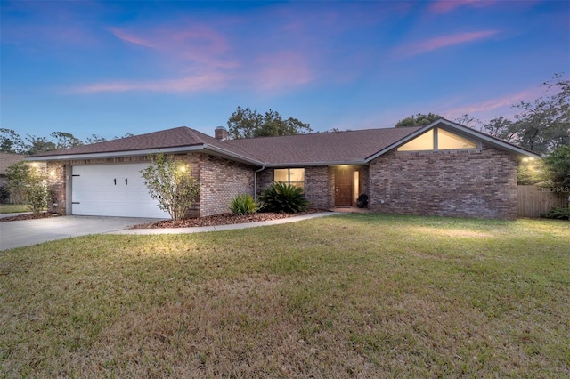 ranch-style house featuring a garage and a yard