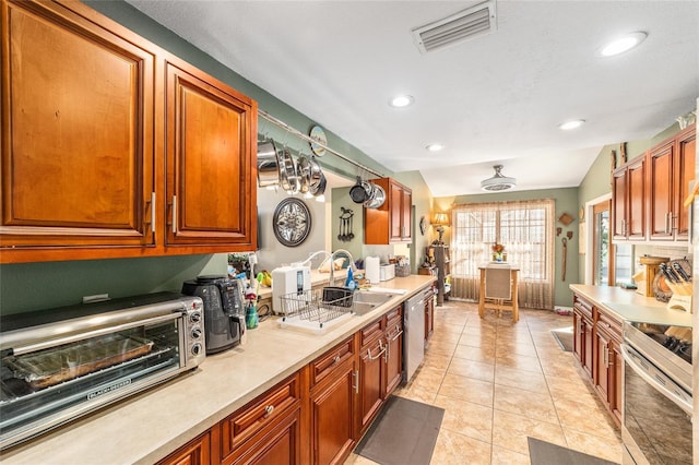 kitchen featuring light tile patterned flooring, stainless steel appliances, and sink