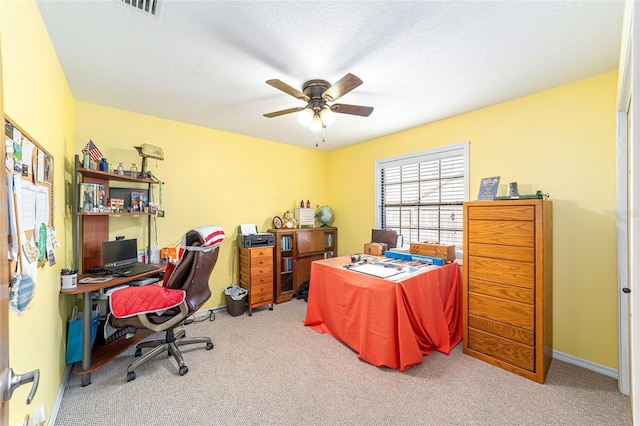 carpeted office featuring a textured ceiling and ceiling fan