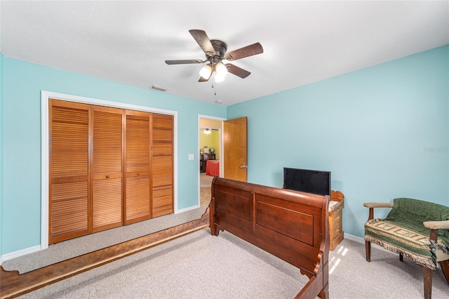 bedroom with light carpet, ceiling fan, and a closet