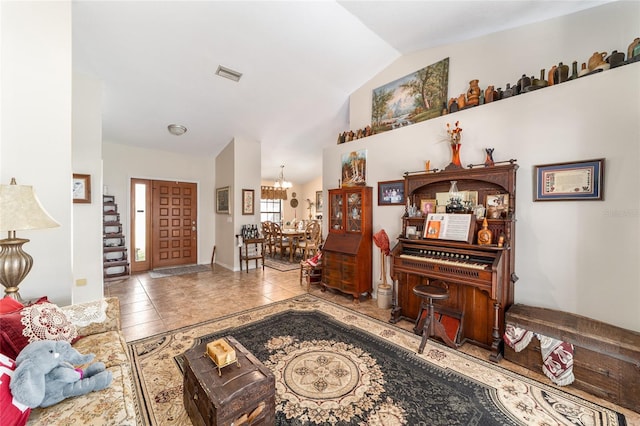 living room featuring vaulted ceiling, tile patterned floors, and a chandelier