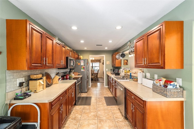 kitchen with light tile patterned flooring, appliances with stainless steel finishes, sink, and decorative backsplash