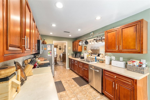 kitchen with stainless steel appliances, light tile patterned flooring, and sink