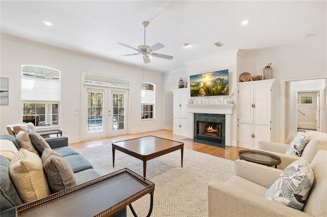 living room with french doors, ornamental molding, ceiling fan, and light hardwood / wood-style flooring